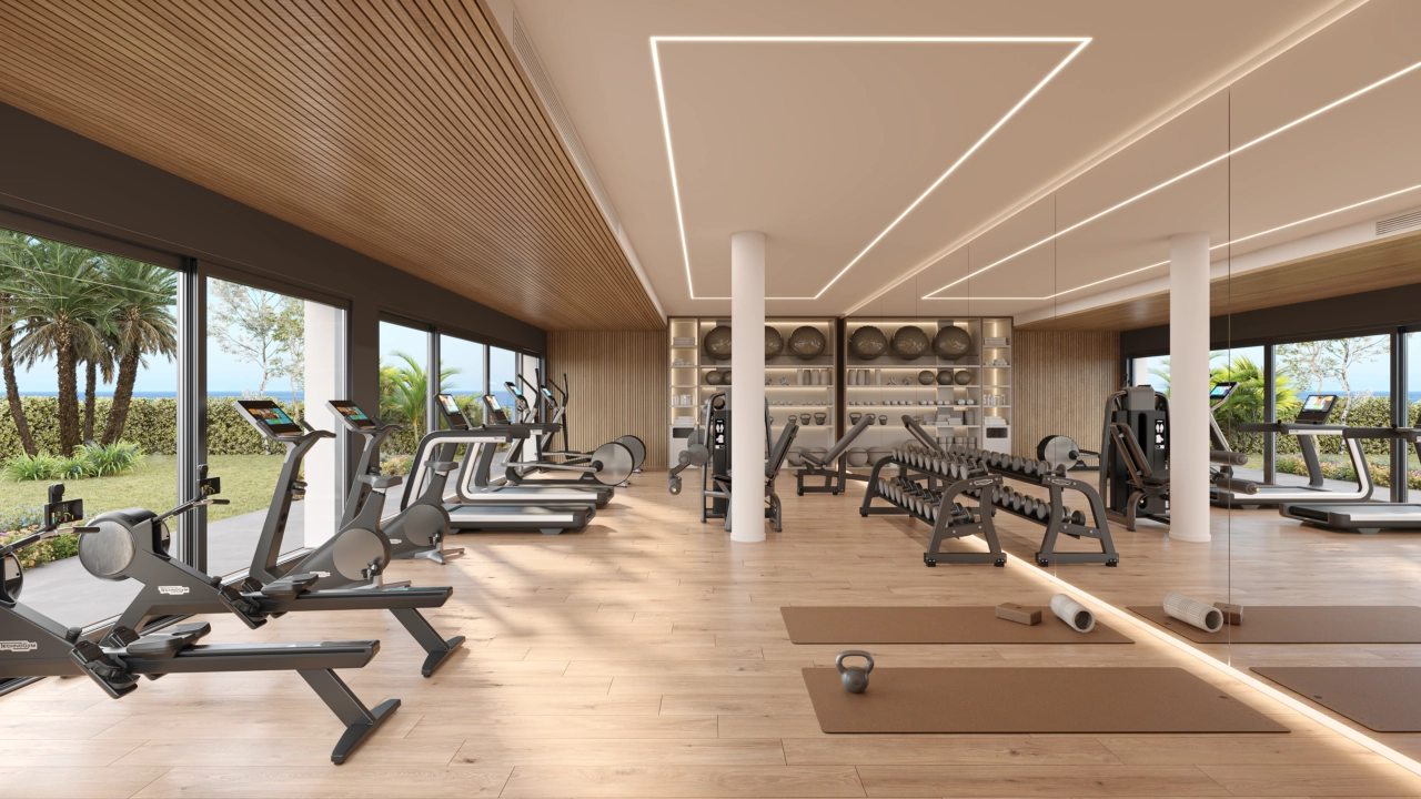Det topmoderne indendørs fitnesscenter er fuldt udstyret til alle dine træningsbehov, med udsigt til haverne.