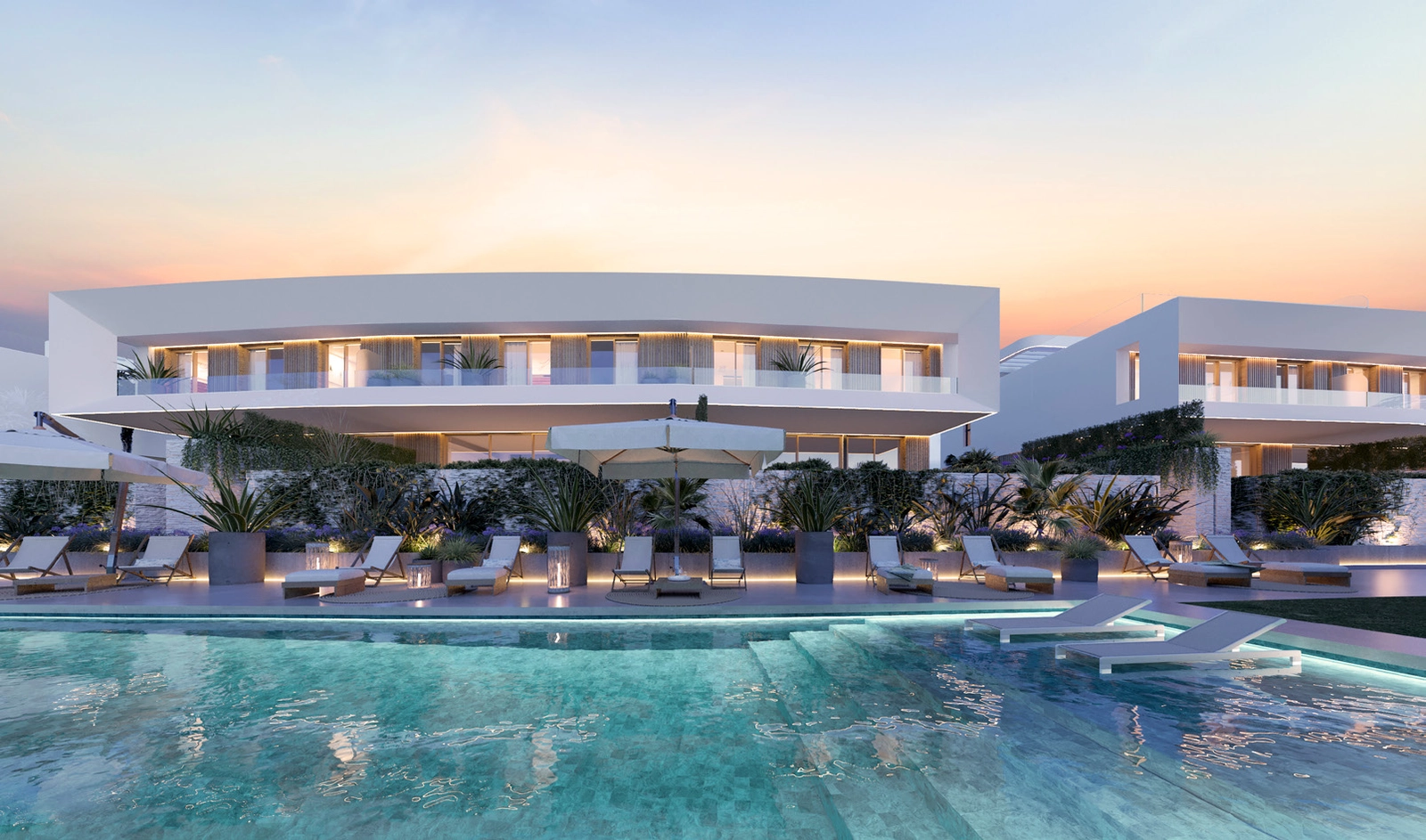 Det elegante fælles swimmingpoolområde, smukt oplyst til aftenafslapning.