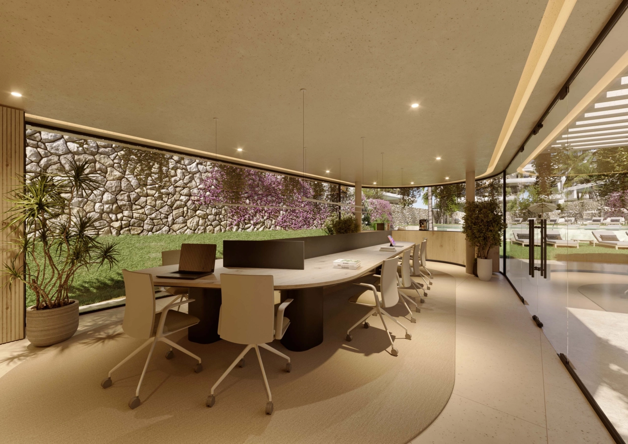 Et fredfyldt co-working område med udsigt til haven, der tilbyder et behageligt og inspirerende miljø til arbejde eller møder.