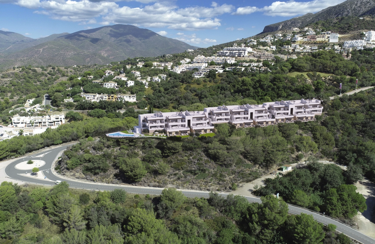 An aerial perspective of the development, showing its beautiful integration within the green hills of Istán.