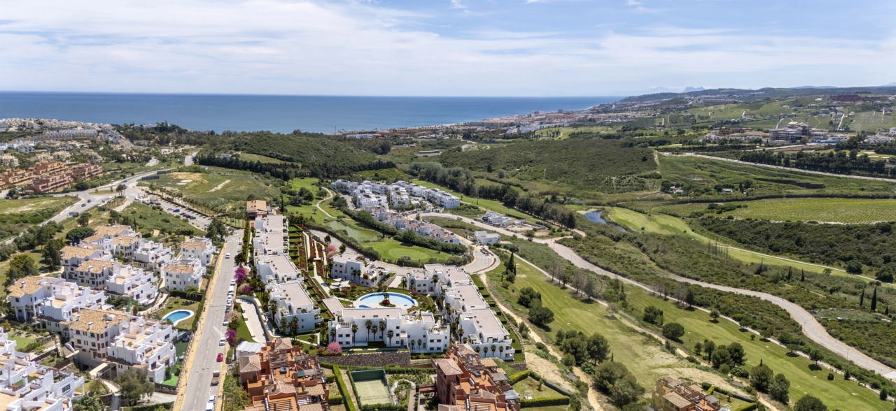 An inspiring aerial view of the development, showcasing its integration with the golf course and the nearby Mediterranean Sea.