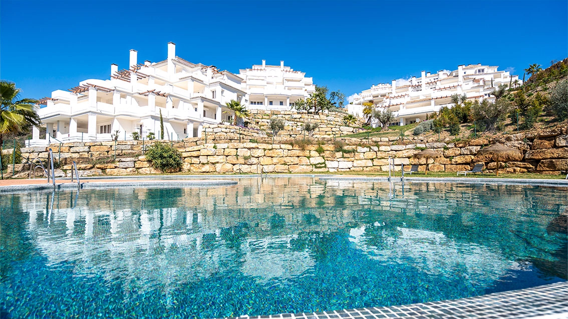 The stunning residential buildings viewed from the communal pool area, showcasing the development's beautiful architecture.