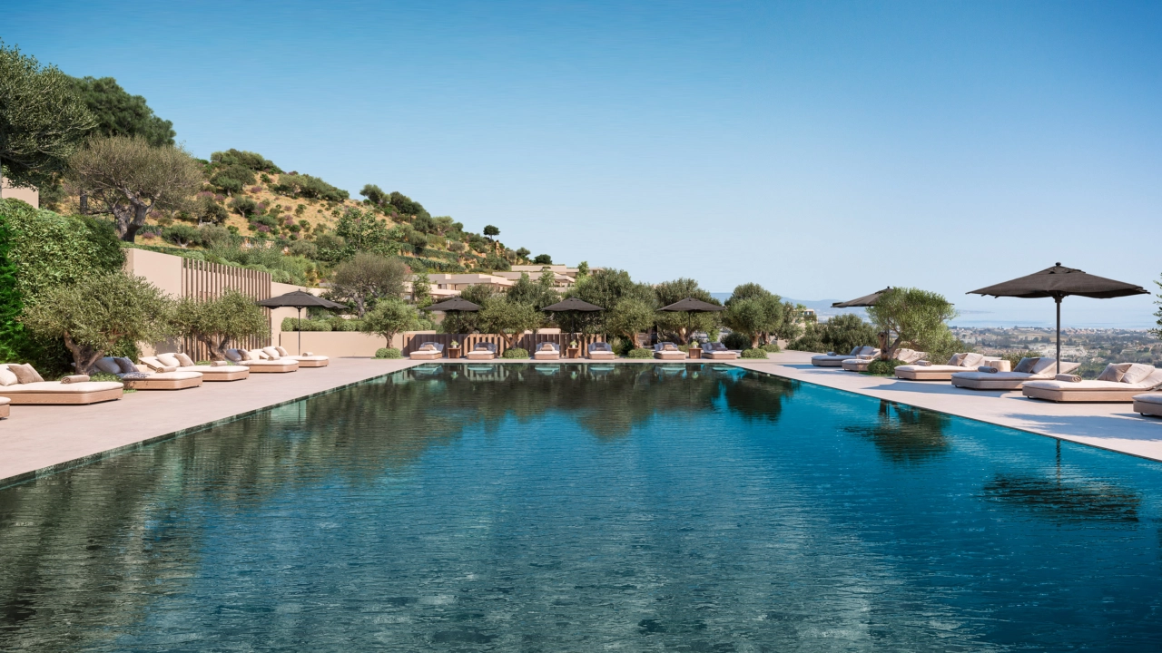 The expansive communal swimming pool, surrounded by lush gardens and comfortable sun loungers.