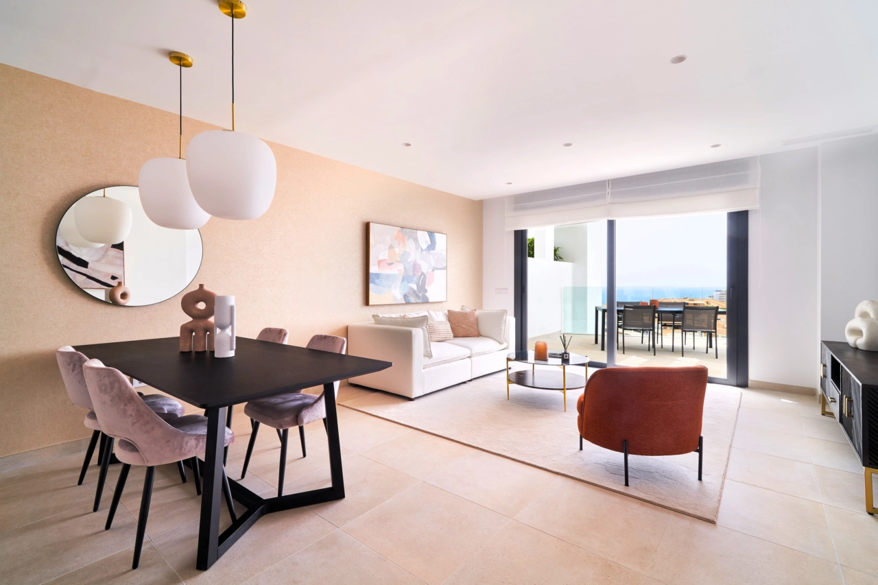 The open-plan living and dining area connects seamlessly to the terrace, framing beautiful views of the Mediterranean Sea.