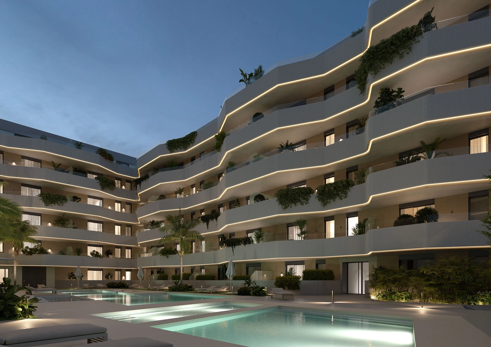 The communal pool and gardens beautifully illuminated at night, creating a magical atmosphere.