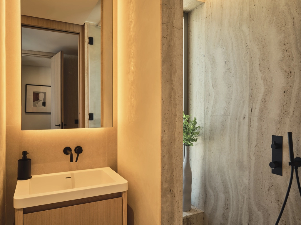 A chic guest bathroom combining natural textures and contemporary fittings to create a warm and inviting space.
