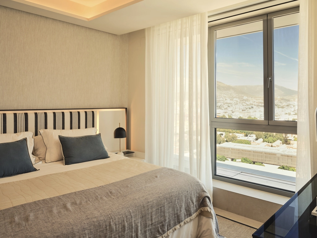 A comfortable and stylish guest bedroom offering city views and a tranquil atmosphere for family or visitors.