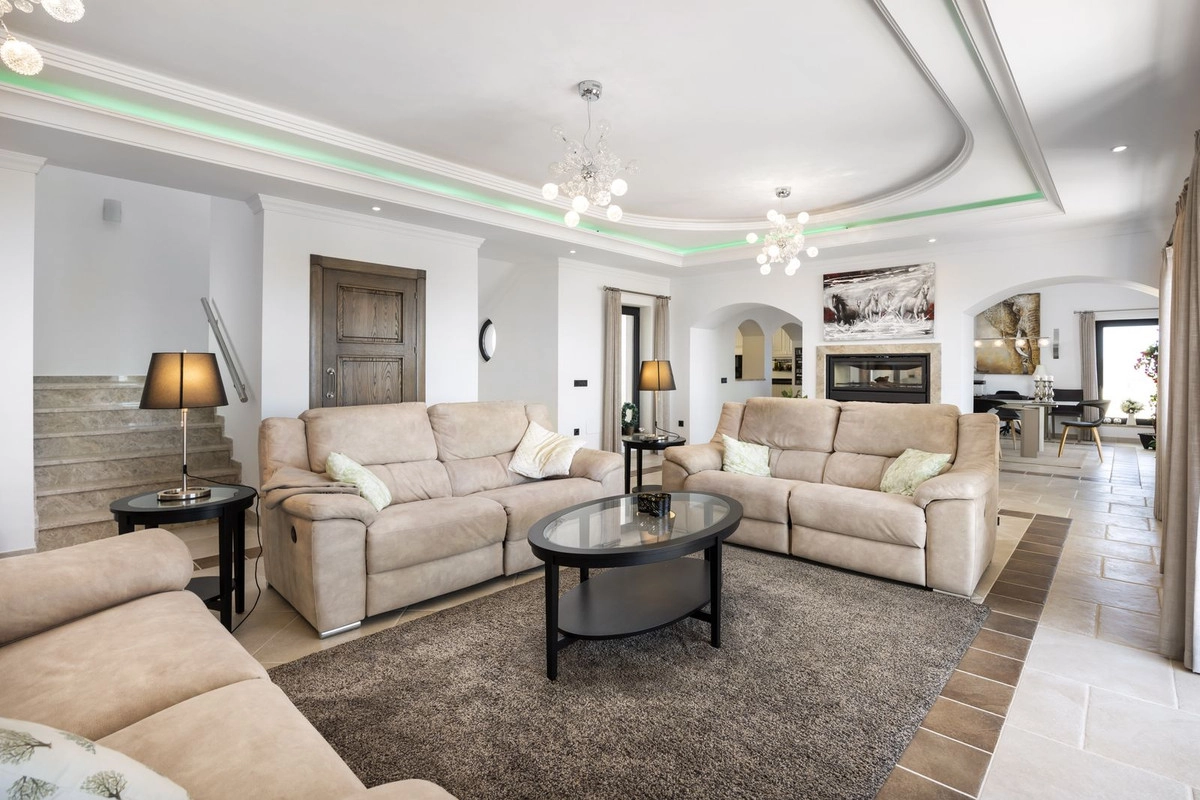 The elegant and spacious living room, filled with natural light, is designed for comfort and relaxation.