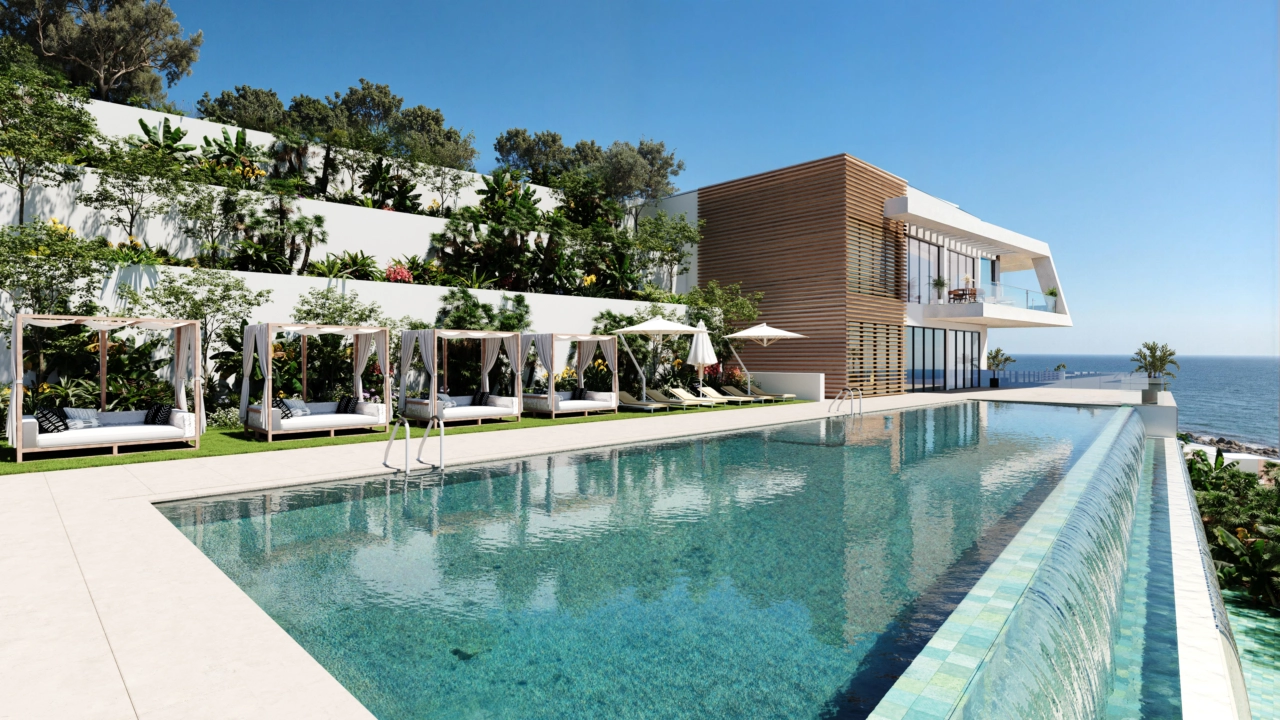 The stunning communal infinity pool, surrounded by lush gardens and offering spectacular sea views.