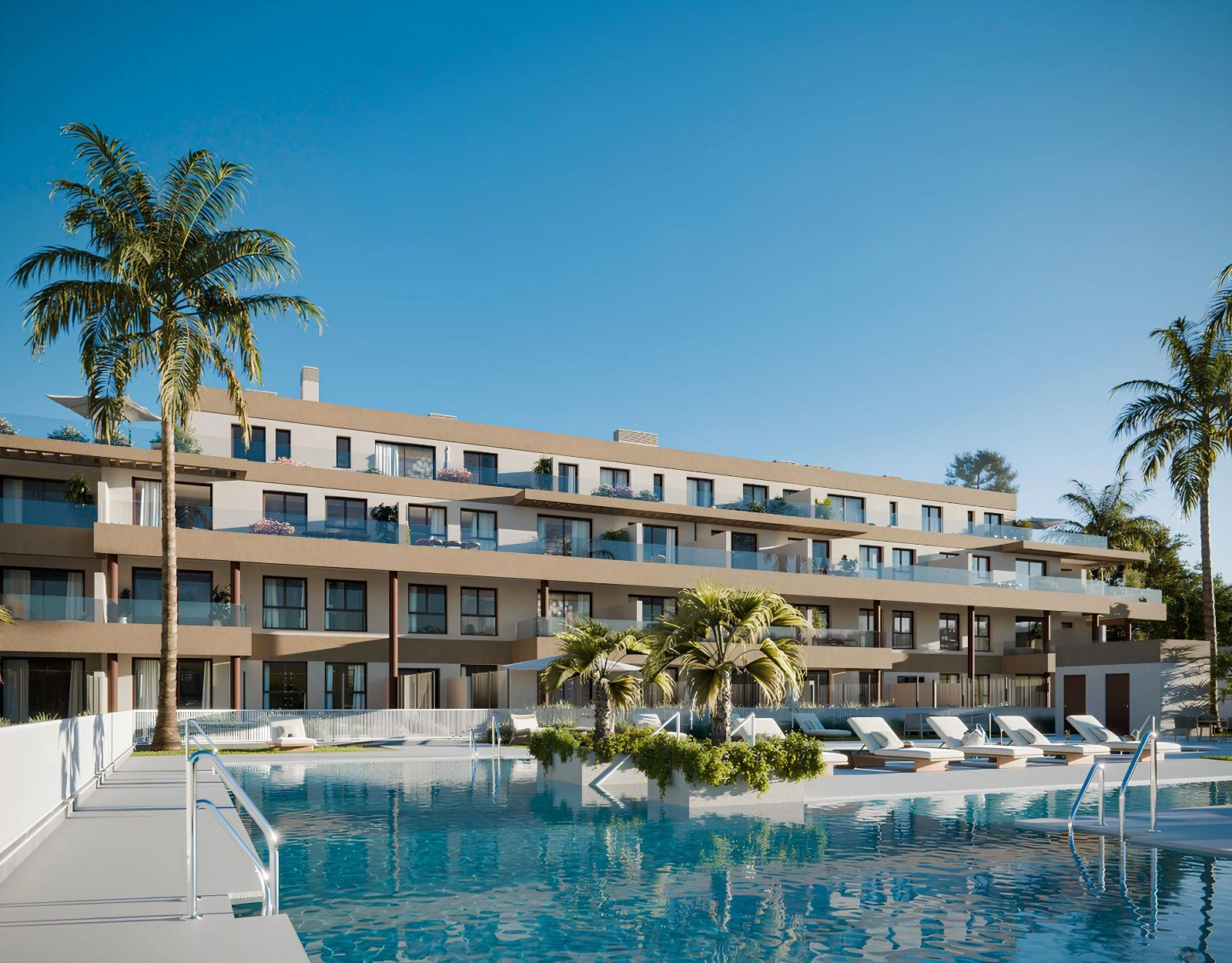 The beautiful communal swimming pool, surrounded by relaxing sunbathing areas and lush palm trees.