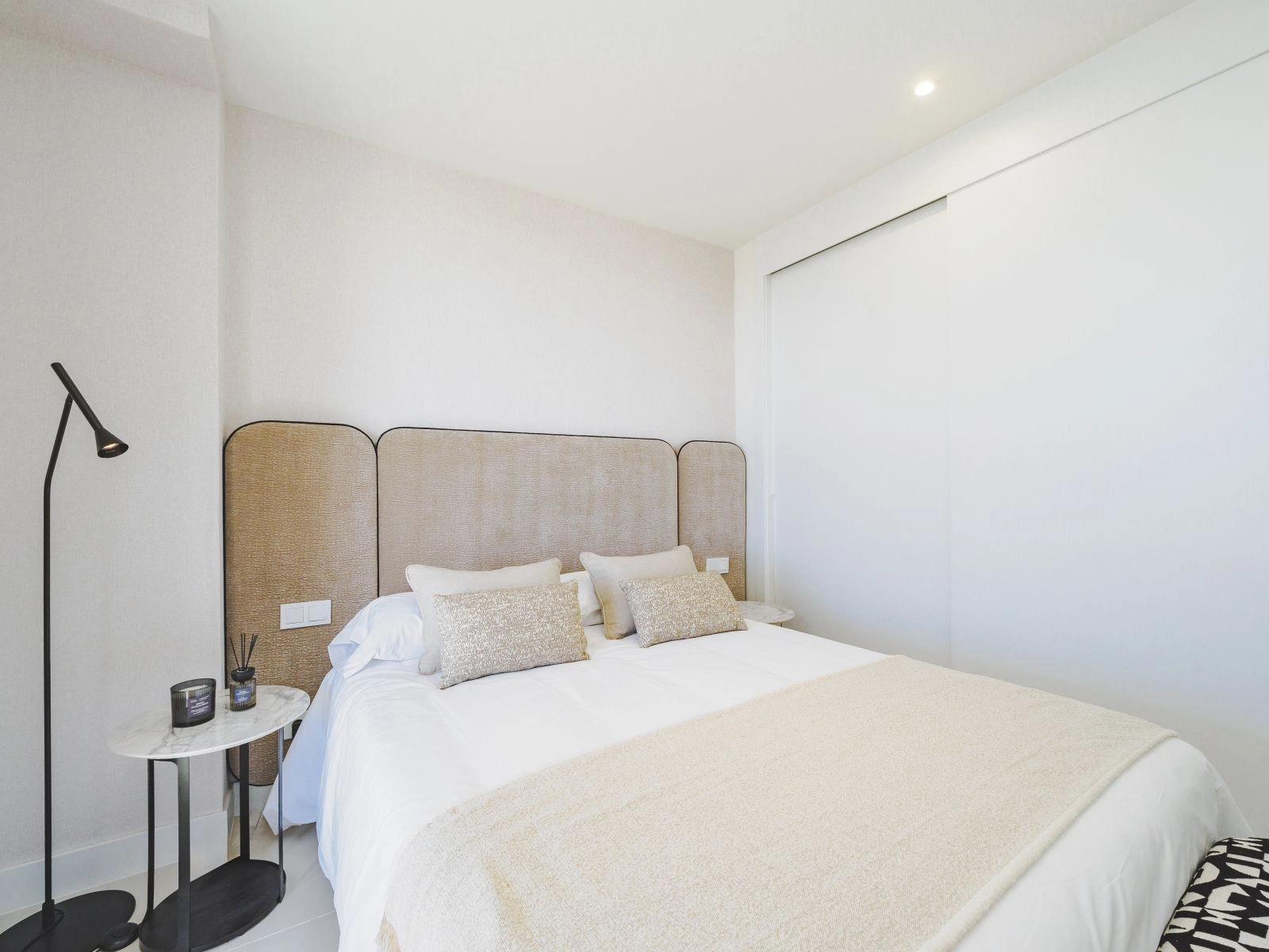 A comfortable guest bedroom featuring clean lines, neutral tones, and built-in storage.