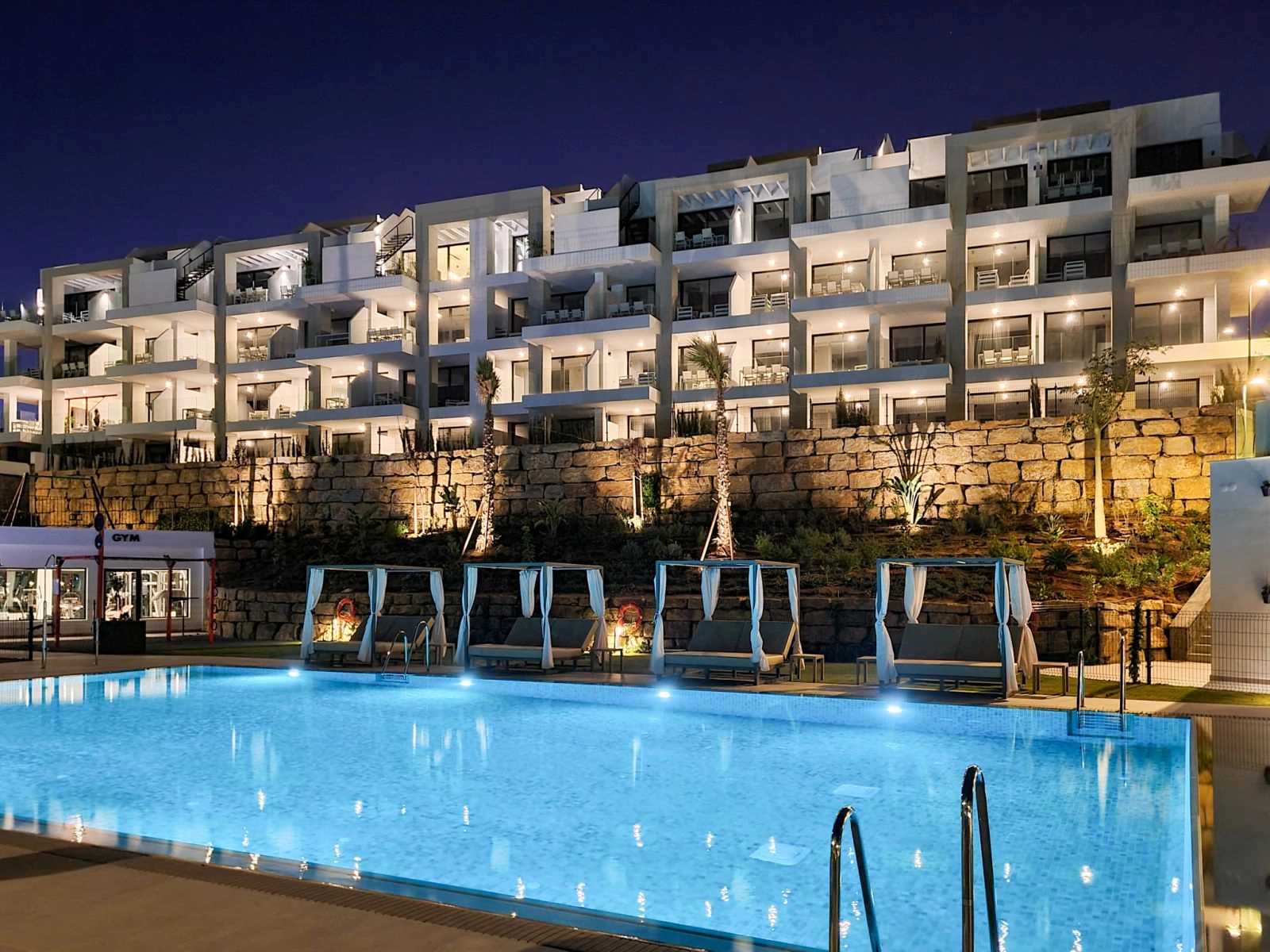 The apartment complex is beautifully illuminated at night, creating an elegant and secure ambiance.