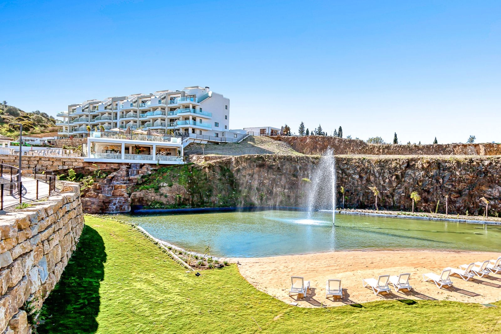 The stunning lagoon feature provides a unique space to relax by the water on a sandy shore.