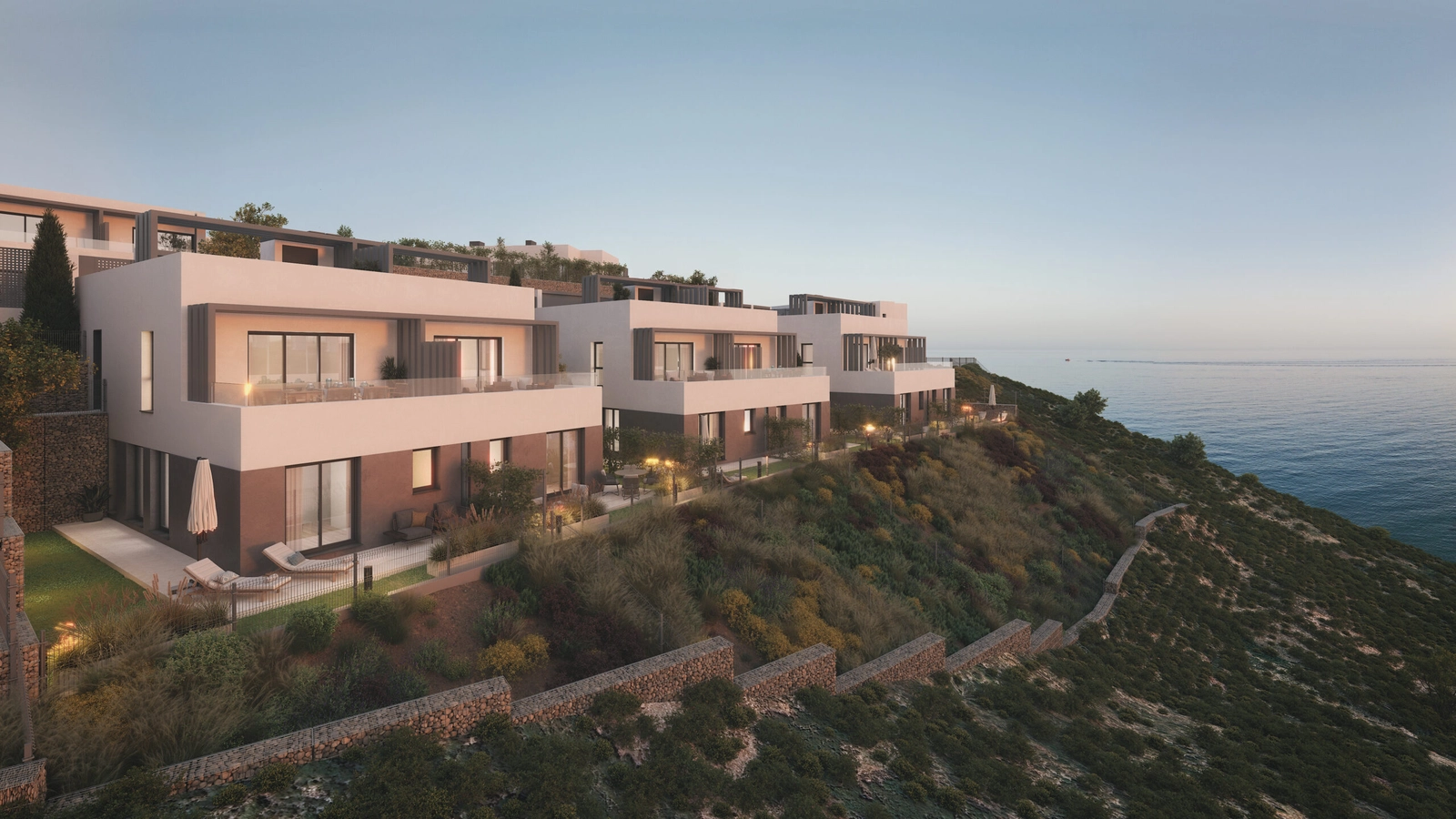 The development's modern architecture blends beautifully with the coastal landscape at dusk.