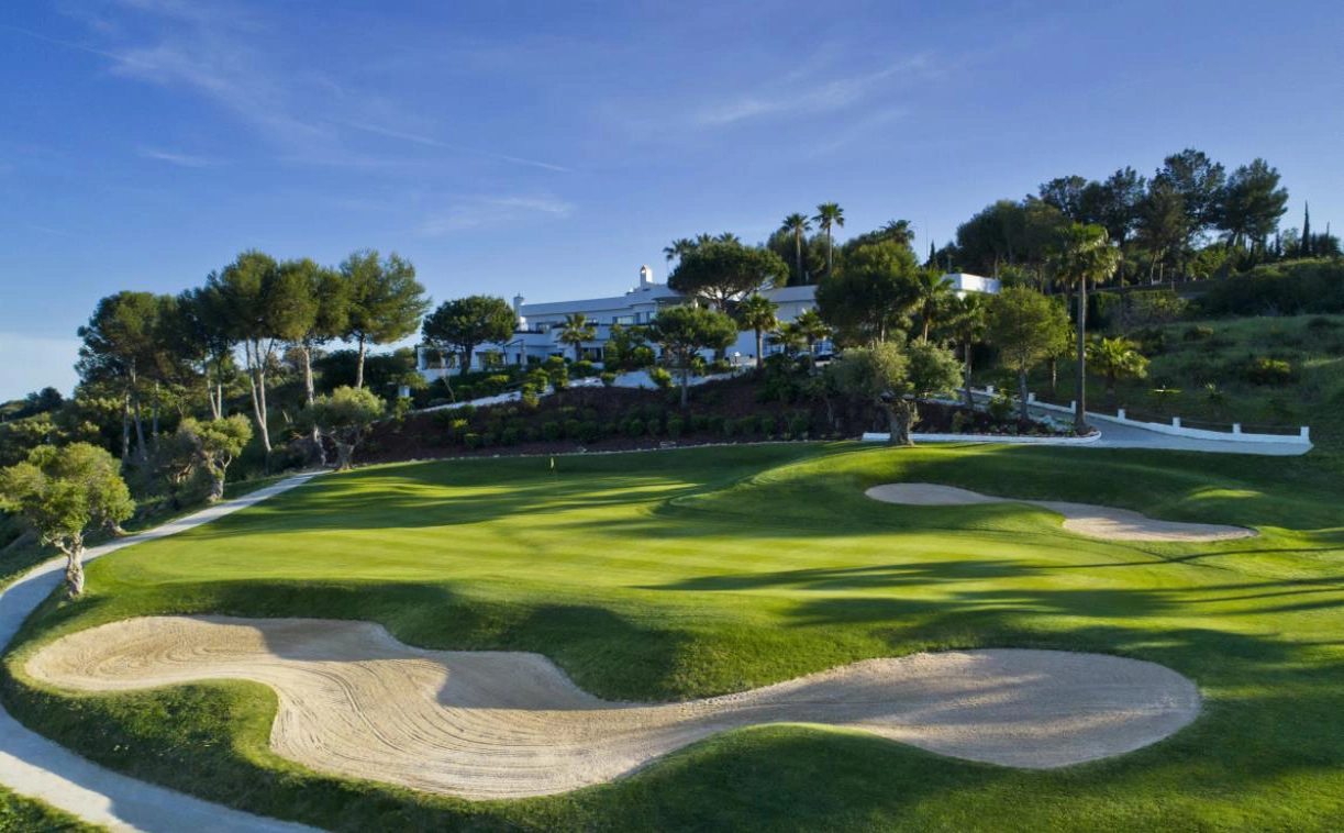 The prestigious Estepona Golf clubhouse, just a short walk from your apartment, set against a backdrop of manicured greens.
