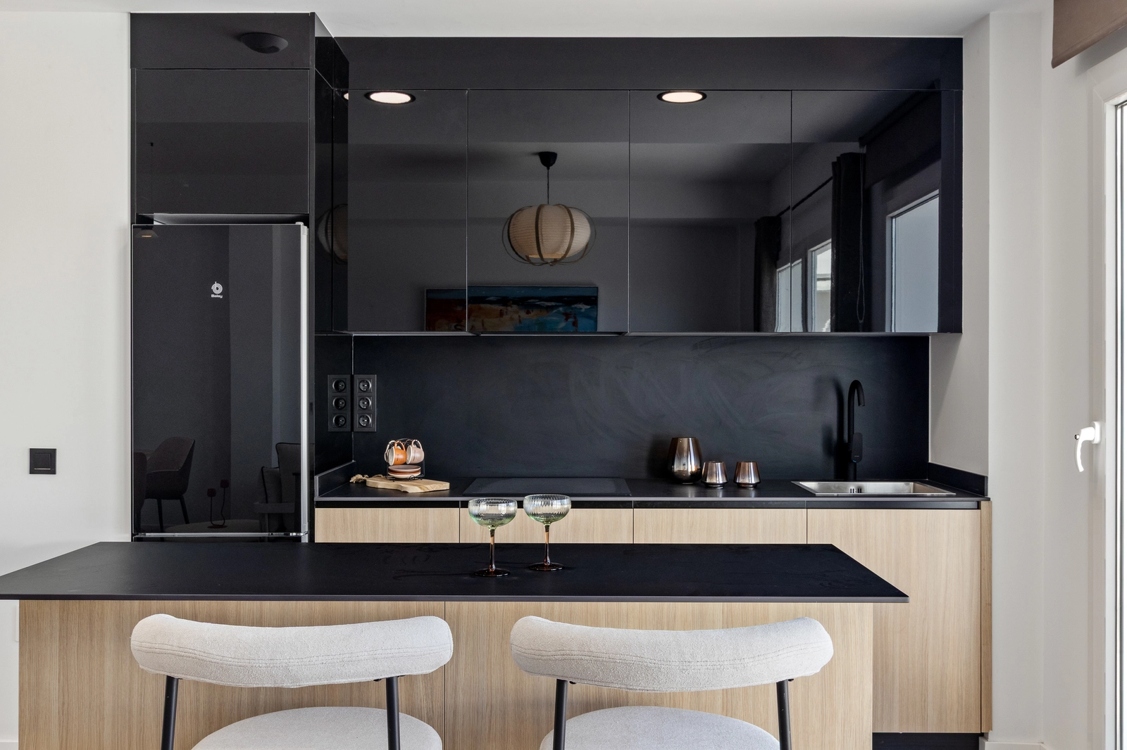 The sleek, modern kitchen is fully equipped with high-quality appliances and features a practical breakfast bar.