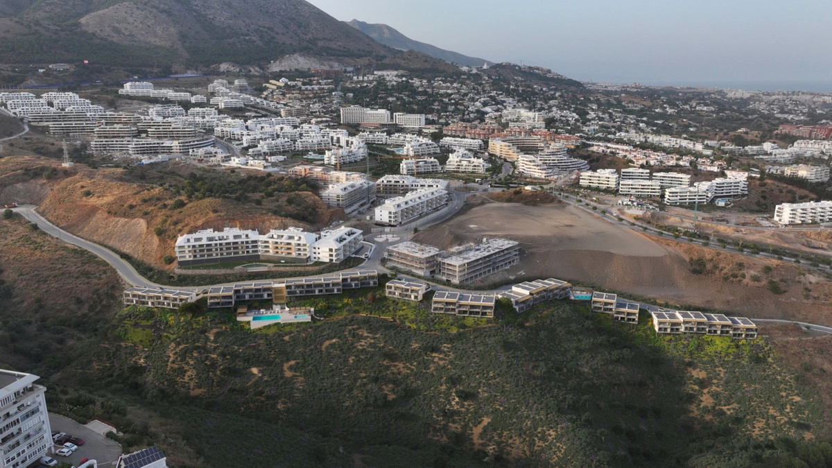 An aerial view showing the development's prime location between the mountains and the sea.