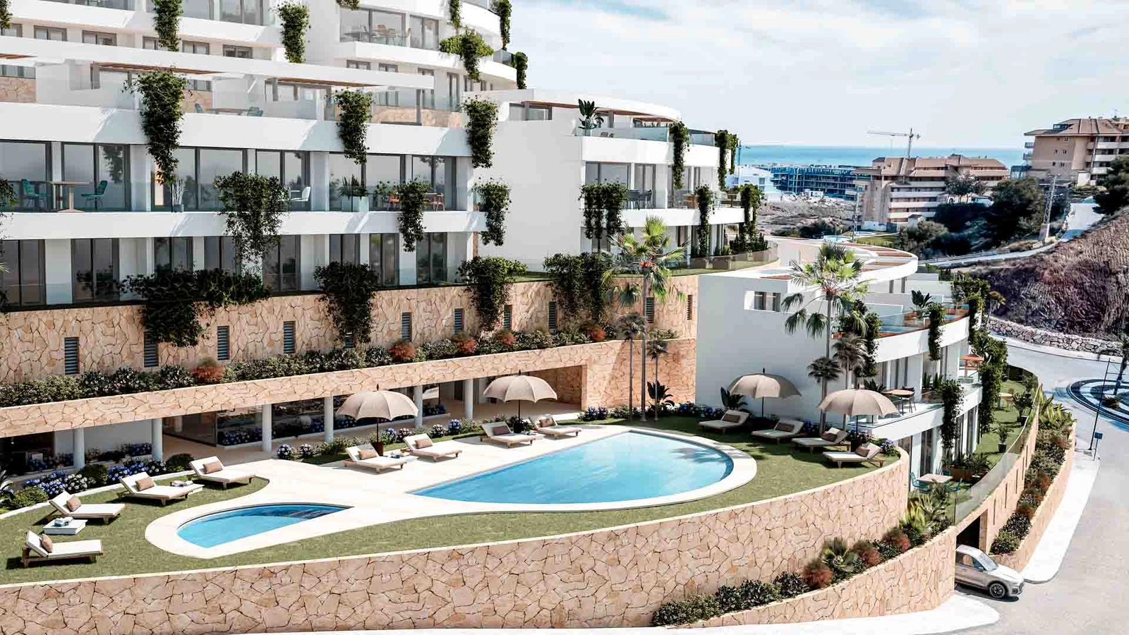 The elegant communal pool area, surrounded by natural stone and lush landscaping.