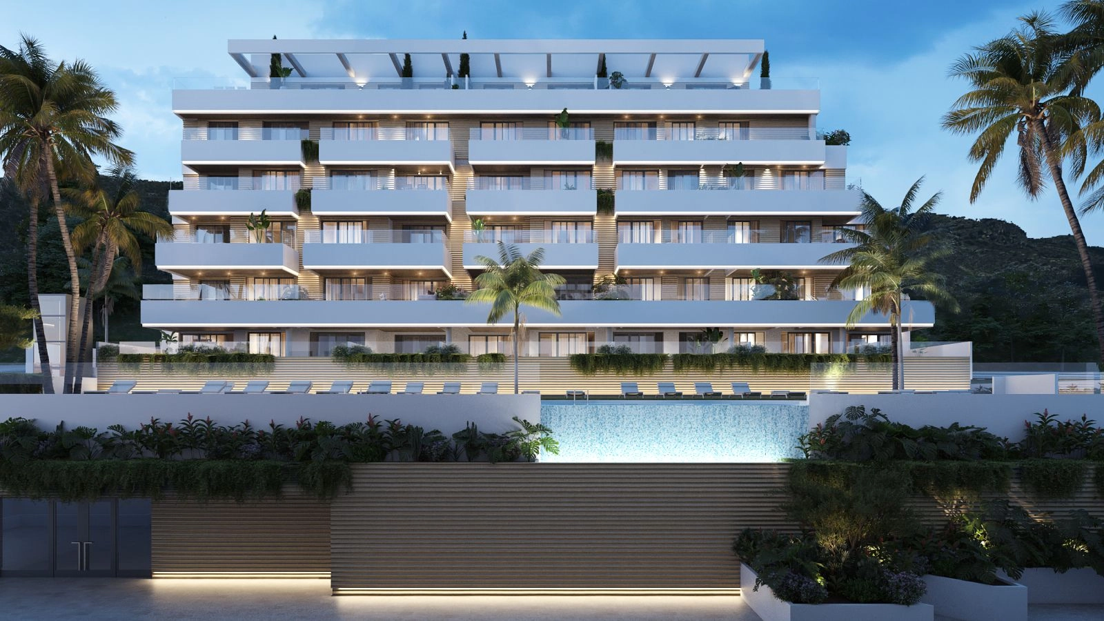 An evening view of the main building, highlighting the elegant lighting and tranquil atmosphere by the pool.