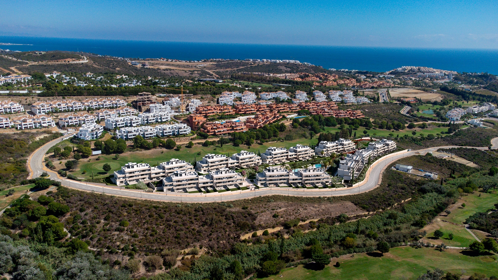 Vista aérea de la urbanización, perfectamente integrada en el verde paisaje del campo de golf de Casares, con el mar Mediterráneo al fondo.
