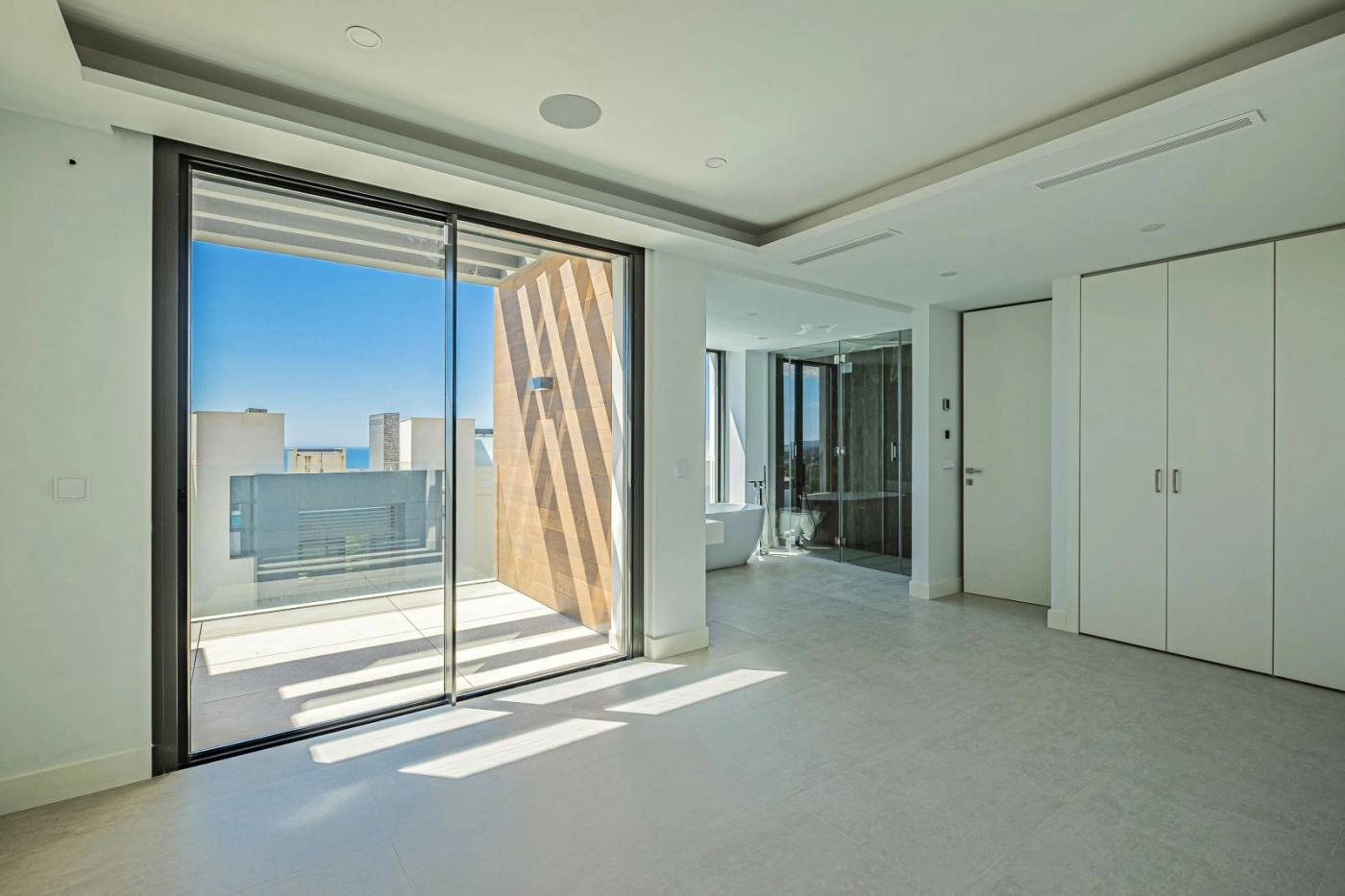 La suite principal ofrece un santuario sereno y espacioso con acceso directo a una terraza privada.