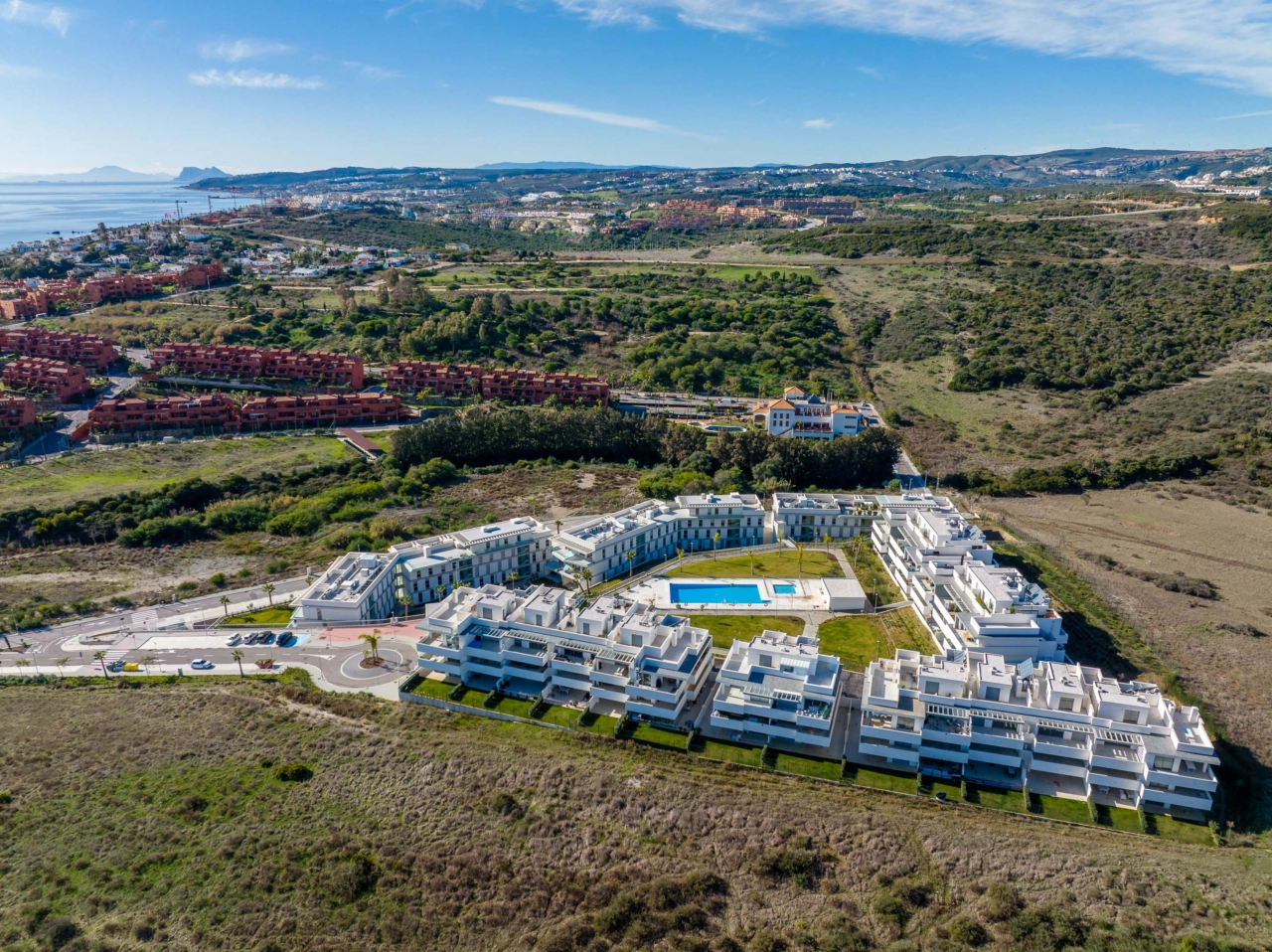La piscina central y la zona para tomar el sol, rodeadas de jardines paisajísticos, crean un oasis privado para los residentes.
