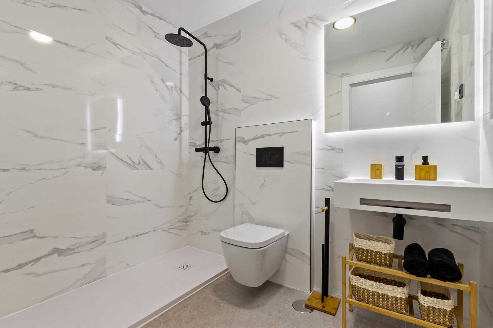 Un baño contemporáneo con acabados de alta calidad, que cuenta con una ducha a ras de suelo y accesorios modernos.