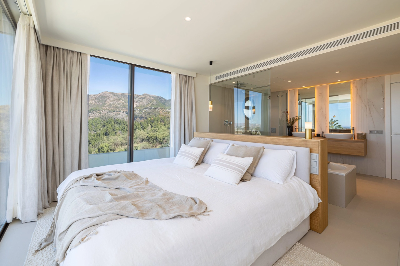 El dormitorio principal es un refugio de paz, con un baño en suite de planta abierta y grandes ventanales con vistas serenas.