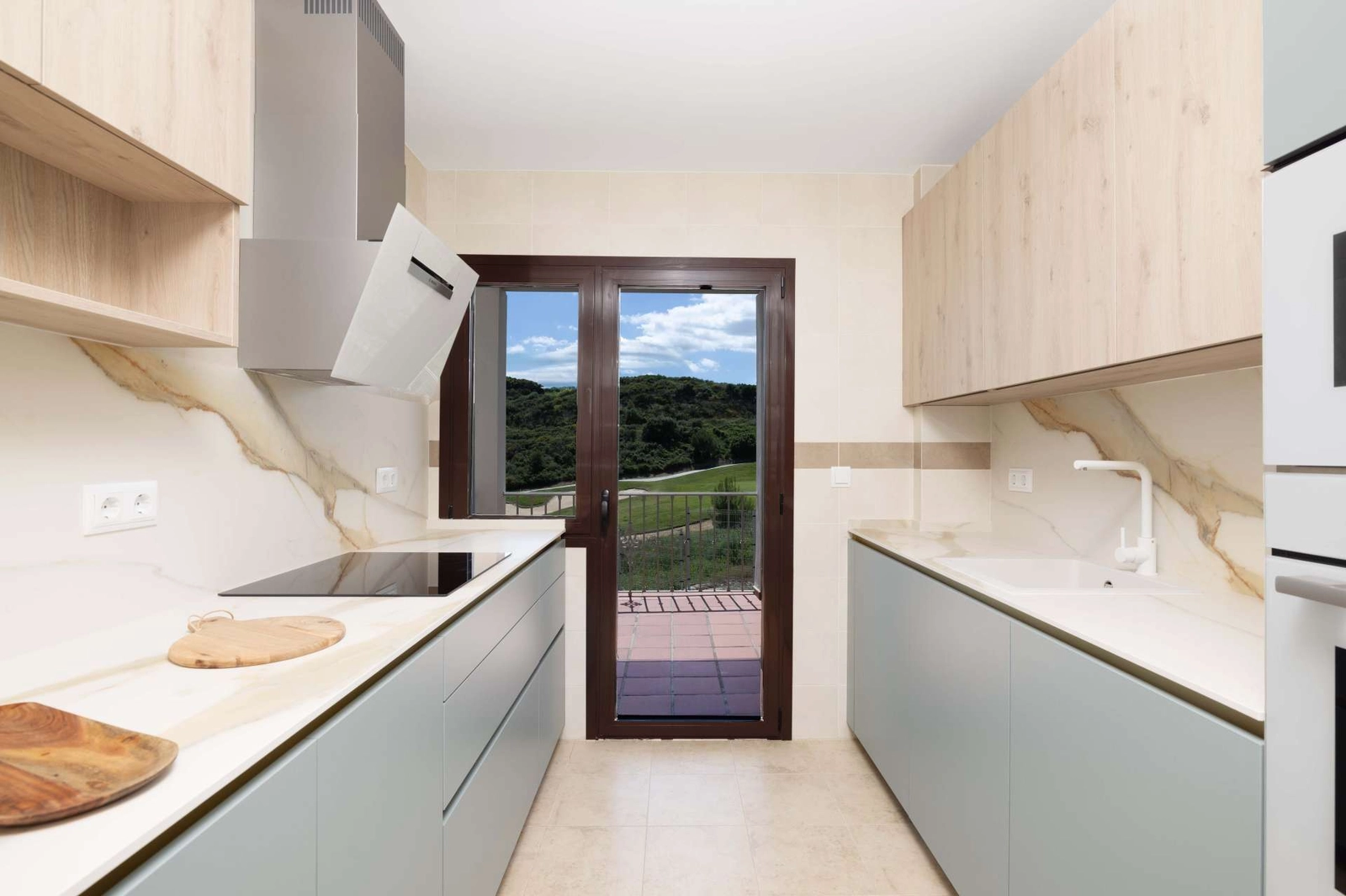 Det moderne kjøkkenet er designet for funksjonalitet og stil, med utsikt mot uteområdet.