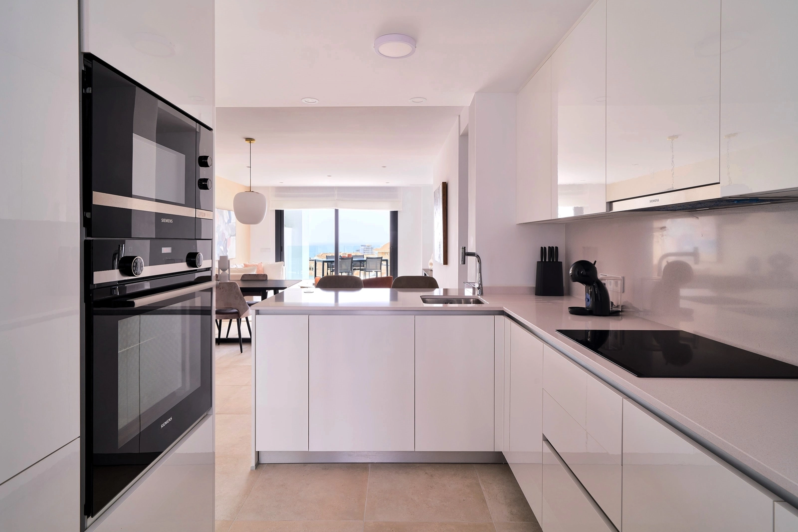 Et moderne, fullt utstyrt kjøkken med frokostbar, designet for både funksjonalitet og stil, med flytende overgang til stuen.